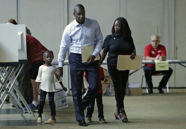 
              Florida Democratic gubernatorial candidate Andrew Gillum walks with his wife R. Jai Gillum, right, and his children Caroline and Jackson as he votes Tuesday, Nov. 6, 2018, in Tallaha...