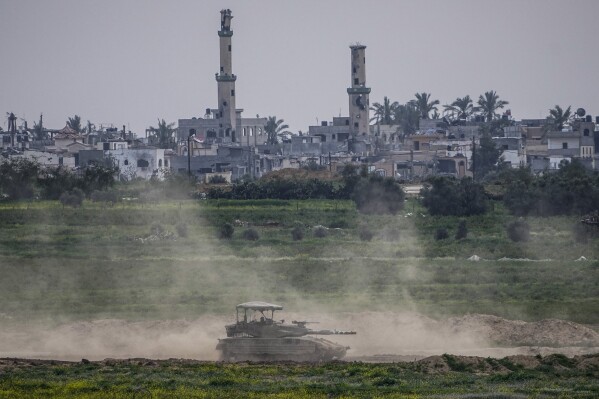 Israeli soldiers drive a tank inside the Gaza Strip, as seen from southern Israel, Tuesday, Feb. 13, 2024. The army is battling Palestinian militants across Gaza in the war ignited by Hamas' Oct. 7 attack into Israel. (AP Photo/Ariel Schalit)