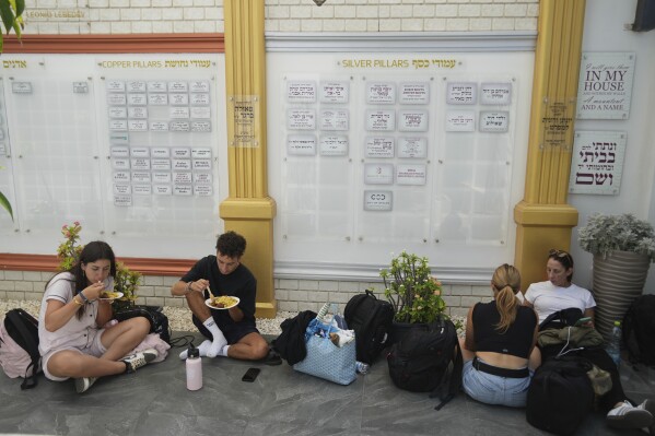 Evacuees from Israel eat food at a Jews community center after they arrived from Israel with a ship, at the port of Larnaca, Cyprus, Wednesday, June 18, 2025. (AP Photo/Petros Karadjias)