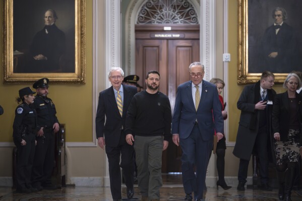 Ukrainian President Volodymyr Zelenskyy, center, is escorted by Senate Minority Leader Mitch McConnell, R-Ky., left, and Senate Majority Leader Chuck Schumer, D-N.Y., and as he comes to the Capitol in Washington to issue a plea for Congress to break its deadlock and approve continued wartime funding for Ukraine, Tuesday, Dec. 12, 2023. (AP Photo/J. Scott Applewhite)