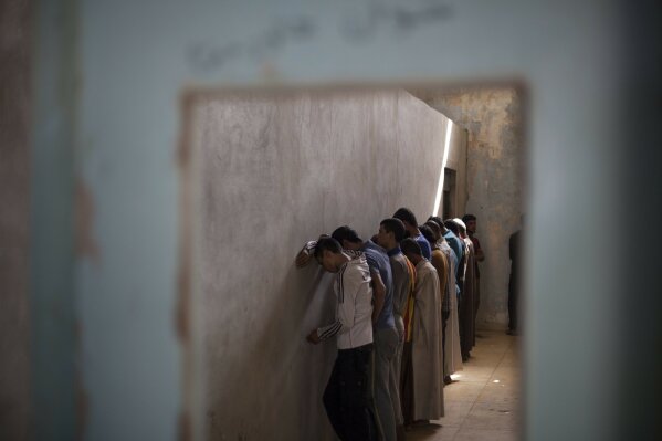 
              FILE - In this Oct. 3, 2017 file photo, displaced men from Hawija stand facing a wall in order not to see security officers, who will try to determine if they were associated with the Islamic State group, at a Kurdish screening center in Dibis, Iraq. In a report released Wednesday, March 6, 2019, Human Rights Watch said Iraqi and Kurdistan Regional Government authorities have charged hundreds of children with terrorism for alleged affiliation with IS, often using torture to coerce confessions. (AP Photo/Bram Janssen, File)
            