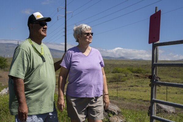 Dana Aina, a firewise community support specialist for the Hawaii Wildfire Management Organization, left, poses for a portrait with his wife, Shelly, an NFPA-trained wildfire home assessor, Tuesday, Feb. 25, 2025, in Waikoloa Village, Hawaii. (AP Photo/Mengshin Lin)