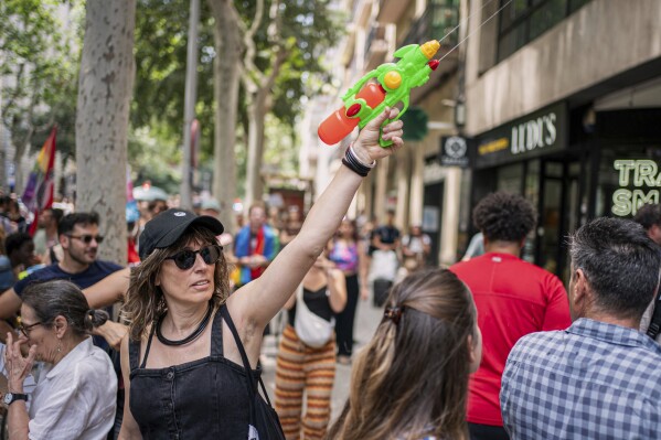 A protester holds a water gun during a protest against overtourism in Barcelona, Spain, Sunday, June 15, 2025. (AP Photo/Pau Venteo)