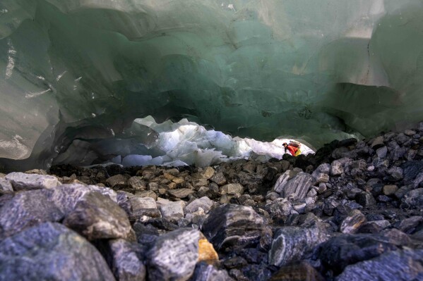 Glaciologist Violeta Lauria from the Austrian Academy of Sciences looks into the Jamtalferner Glacier near Galtuer, Austria, Wednesday, Sept. 6, 2023. (AP Photo/Matthias Schrader)