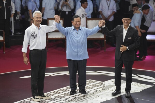 FILE - Presidential candidates, from left, Ganjar Pranowo, Prabowo Subianto and Anies Baswedan hold hands as they pose for photographers after the first presidential candidates' debate in Jakarta, Indonesia, Tuesday, Dec. 12, 2023. Indonesia’s electoral commission announced on Wednesday, March 20, 2024, that Defense Minister Subianto, a former general linked to past human rights abuses, was elected president. The results immediately drew allegations of fraud from Subianto’s political rivals.(AP Photo/Tatan Syuflana, File)