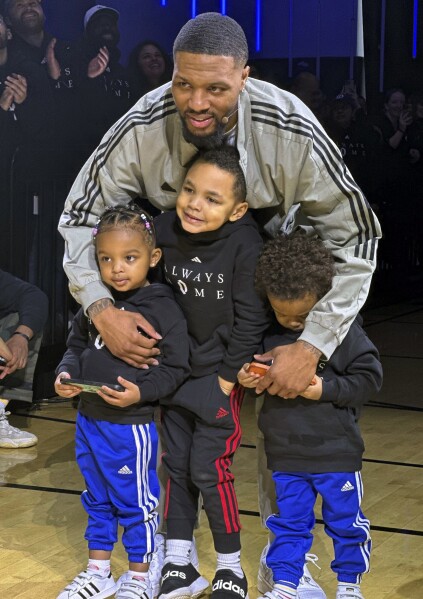 Milwaukee Bucks point guard Damian Lillard poses with his children at an event on Tuesday, Jan. 30, 2024 in Portland, Ore. Lillard was playing in Portland for the first time since he was traded from the Trail Blazers to the Bucks in the offseason. (AP Photo/Anne M. Peterson)