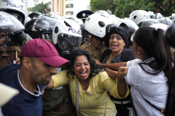 Anti government protesters scuffle with police officers as police blocked their protest march in Colombo, Sri Lanka, Wednesday, Nov. 2, 2022. The protestors were demanding the release of two detained  protest leaders and to end the government’s crackdown on protests against an unprecedented economic crisis that has engulfed the island nation for months. (AP Photo/Eranga Jayawardena)