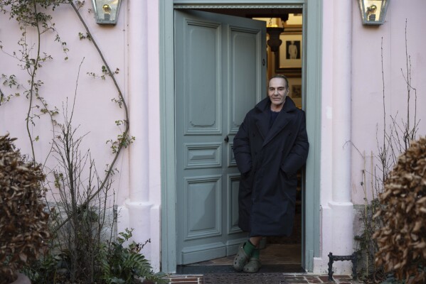 This image released by MUBI shows fashion designer John Galliano in the doorway of his home in a scene from the documentary film, “High & Low --John Galliano," directed by Kevin Macdonald. (MUBI via AP)