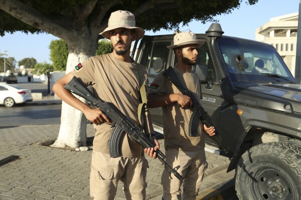 FILE - Libyan security forces stand guard in Tripoli, Libya, Tuesday, Aug. 16, 2023. One of Libya’s rival prime ministers warned Thursday, Aug. 17, 2023, that his government would not tolerate any further militia fighting, days after the year’s bloodiest bout of clashes rocked the capital, Tripoli, killing at least 45 people. (AP Photo/Yousef Murad, File)
