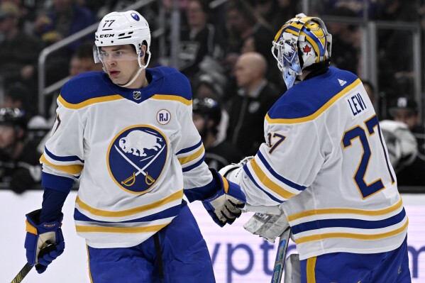 Buffalo Sabres right wing JJ Peterka (77) gets congratulation from goaltender Devon Levi (27) after Peterka scored a goal against the Los Angeles Kings during the second period of an NHL hockey game in Los Angeles, Wednesday, Jan. 24, 2024. (AP Photo/Alex Gallardo)