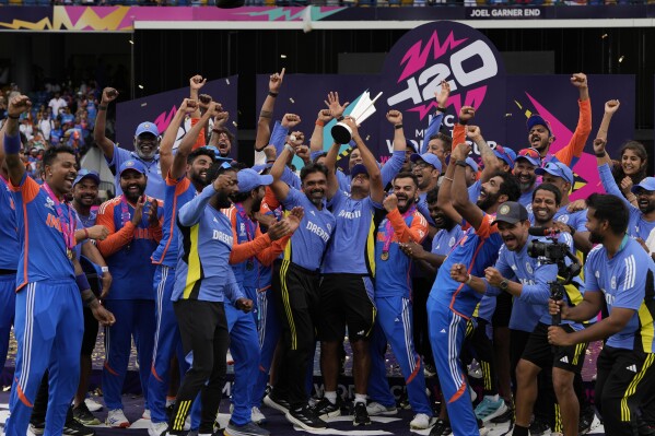 India's head coach Rahul Dravid, center, and players celebrate with the winners trophy after defeating South Africa in the ICC Men's T20 World Cup final cricket match at Kensington Oval in Bridgetown, Barbados, Saturday, June 29, 2024. (AP Photo/Ricardo Mazalan)ASSOCIATED PRESS