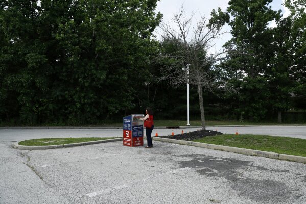 FILE - In this July 1, 2020, file photo, Marianne Carver, of Pennsauken, N.J., drops off her ballot for the New Jersey primary election at a vote-by-mail drop box in a parking lot at Camden County College in Cherry Hill, N.J. Amid the global pandemic, more people than ever are expected to bypass their polling place and cast absentee ballots for the first time. Voters marking ballots from home could lead to an increase in the kinds of mistakes that typically would be caught by a scanner or election worker at the polls. (AP Photo/Matt Slocum, File)