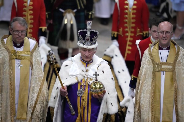 FILE - Britain's King Charles III, center, walks in the Coronation Procession after his coronation ceremony at Westminster Abbey in London, May 6, 2023. King Charles III’s decision to be open about his cancer diagnosis has helped the new monarch connect with the people of Britain and strengthened the monarchy in the year since his dazzling coronation at Westminster Abbey. (AP Photo/Kirsty Wigglesworth, Pool, File)