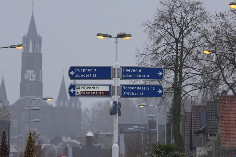 The church of Sint Willesbrord, Netherlands, serves as a backdrop for street signs at a roundabout on Friday, Dec. 1, 2023. (AP Photo/Virginia Mayo)
