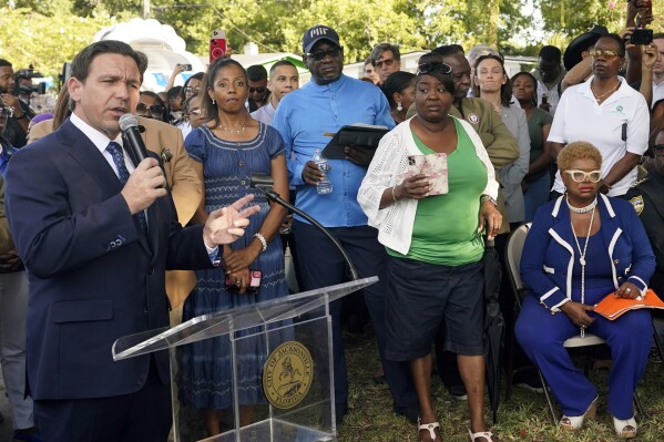 FILE - Florida Gov. Ron DeSantis, left, speaks at a prayer vigil for the victims of a mass shooting a day earlier, in Jacksonville, Fla., Sunday, Aug. 27, 2023. (AP Photo/John Raoux, File)