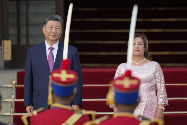 Peru's President Dina Boluarte, right, and Chinese President Xi Jinping face the honor guard during a welcome ceremony at the government palace in Lima, Peru, Thursday, Nov. 14, 2024, on the sidelines of the Asia-Pacific Economic Cooperation (APEC) summit. (AP Photo/Fernando Vergara)