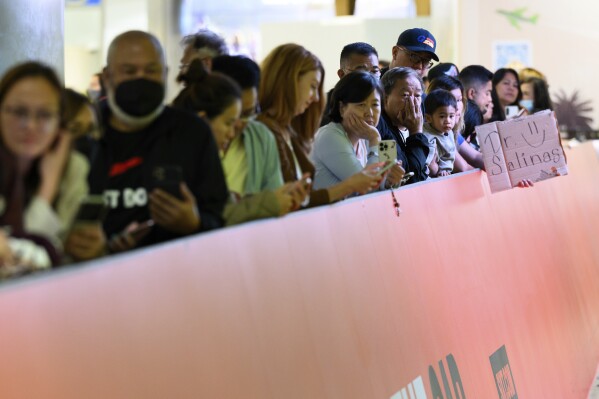 People wait for friends and family at the international arrivals area at the Los Angeles International Airport in Los Angeles, Saturday, June 8, 2025. (AP Photo/William Liang)