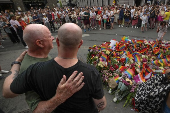FILE - People comfort each other at the scene of a shooting in central Oslo, Norway, on June 25, 2022. Zaniar Matapour, a Norwegian citizen originally from Iran, was Friday, Nov. 10, 2023, charged with aggravated terrorism for the 2022 deadly shooting ahead of an LGBTQ festival in the Norwegian capital’s nightlife district. The shooting at three locations, including outside the London Pub, a popular gay bar in downtown Oslo, on June 25, 2022. Two people were killed and nine wounded. (AP Photo/Sergei Grits)