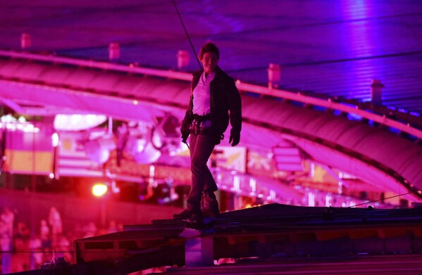 Actor Tom Cruise stands on the roof of the Stade de France  during the closing ceremony of the 2024 Summer Olympics, at the Stade de France, Sunday, Aug. 11, 2024, in Saint-Denis, France. (Fabrizio Bensch/Pool Photo via AP)
