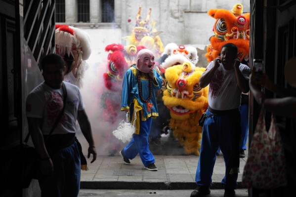 Dancers in lion, dragon and a pig costumes perform to mark the Chinese New Year, the Year of the Wooden Dragon, in Lima, Peru, Friday, Feb. 9, 2024. (AP Photo/Martin Mejia)