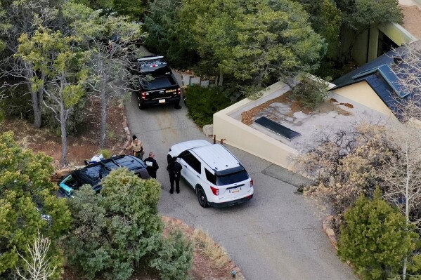 Law enforcement officials talk outside the home of actor Gene Hackman on Feb. 27, 2025 in Santa Fe, New Mexico. (AP Photo/Roberto Rosales, file)
