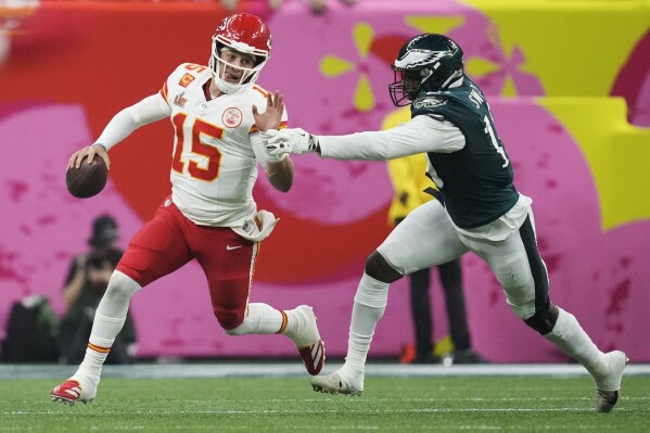 Kansas City Chiefs quarterback Patrick Mahomes (15) eludes the reach of Philadelphia Eagles linebacker Josh Sweat during the second half of the NFL Super Bowl 59 football game on Feb. 9, 2025, in New Orleans. (AP Photo/Ashley Landis, File)