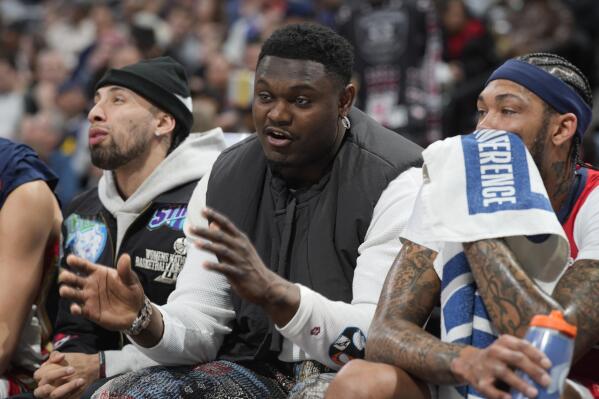 New Orleans Pelicans forward Zion Williamson, center, sits on the bench between guard Jose Alvarado, left, and forward Brandon Ingram during the first half of the team's NBA basketball game against the Denver Nuggets on Thursday, March 30, 2023, in Denver. (AP Photo/David Zalubowski)