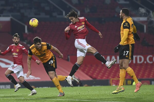 Manchester United's Edinson Cavani tries to score with a header during the English Premier League soccer match between Manchester Utd and Wolverhampton Wanderers at Old Trafford stadium in Manchester, England, Tuesday,Dec. 29, 2020. (Laurence Griffiths, Pool via AP)