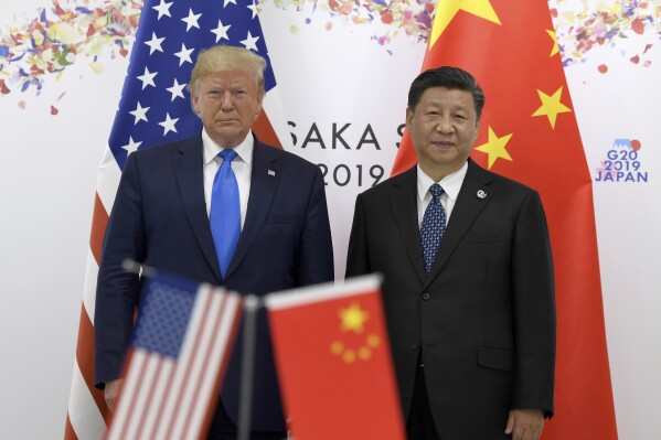 President Donald Trump, left, poses for a photo with Chinese President Xi Jinping during a meeting on the sidelines of the G-20 summit in Osaka, Japan, June 29, 2019. (AP Photo/Susan Walsh, File)