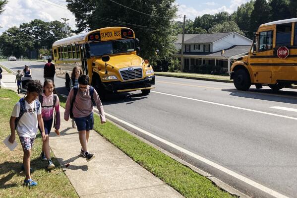 Children walk home from Camp Creek Elementary School in Lilburn, Ga., after school on Monday, Sept. 12, 2022. Polls show K-12 education trailing among voter concerns in Georgia this year as candidates talk more about inflation, the economy, abortion and guns. (AP Photo/Jeff Amy)