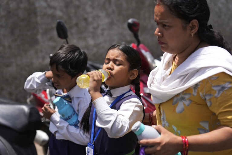 A schoolgirl takes a drink on a hot summer day in Lucknow, India, Friday, May 3, 2024. (Ǻ Photo/Rajesh Kumar Singh)
