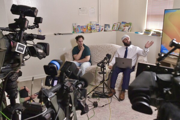 Adnan Syed, right, presents evidence of alleged prosecutorial misconduct during a media conference at his family's home as his younger brother Yusuf Syed listens, Tuesday, Sept. 19, 2023, in Windsor Mill, Md. (Amy Davis/The Baltimore Sun via AP)