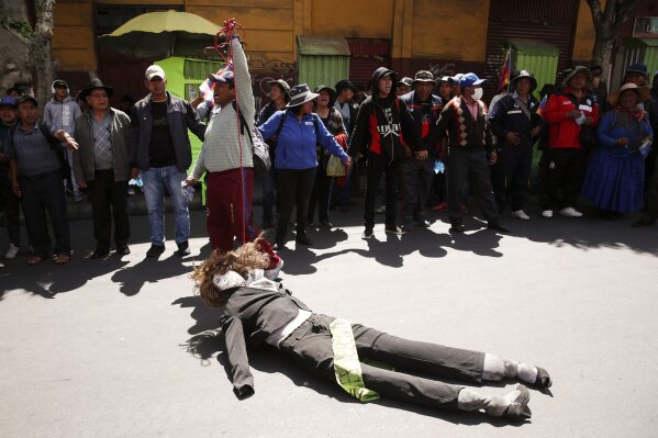 An anti-government demonstrator drags a dummy representing Bolivia's interim President Jeanine Anez in La Paz, Bolivia, Thursday, Nov. 21, 2019. Anez sent a bill on holding new elections to congress Wednesday amid escalating violence that has claimed at least 30 lives since a disputed Oct. 20 vote and the subsequent resignation and self-imposed exile of former President Evo Morales. (AP Photo/Natacha Pisarenko)