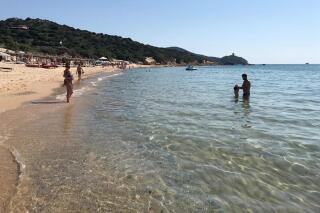 FILE - In this June 29, 2019 photo, people enjoy the white sand and pristine waters of Chia beach, on the Italian island of Sardinia, Italy. Italian media on Saturday, June 5, 2021 said customs police on the Mediterranean island issued fines of up to 3,000 euro ($3,600) to 41 persons who in recent days tried to leave the island with a total of some 100 kilos (220 pounds) of sand, seashells and beach rocks. (AP Photo/Karl A.Ritter)