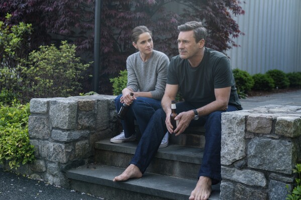 This image released by Apple TV+ shows Amanda Peet, left, and Jon Hamm in a scene from "Your Friends & Neighbors." (Jessica Kourkounis/Apple TV+ via AP)