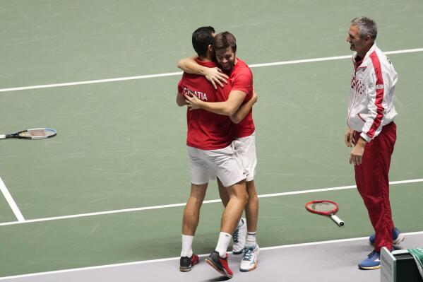 Croatia's Mate Pavic, left, celebrates with his teammate Nikola Mektic, center, and his captain Vedran Martic after winning against Italy's Fabio Fognini and Jannik Sinner during their Davis Cup men's doubles Finals tennis match at the Pala Alpitour in Turin, Italy, Monday, Nov. 29, 2021. (AP Photo/Antonio Calanni)