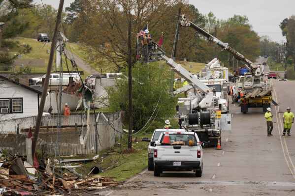 Utility workers tend to damaged power lines following severe weather in Selmer, Tenn., Thursday, April 3, 2025. (AP Photo/George Walker IV)