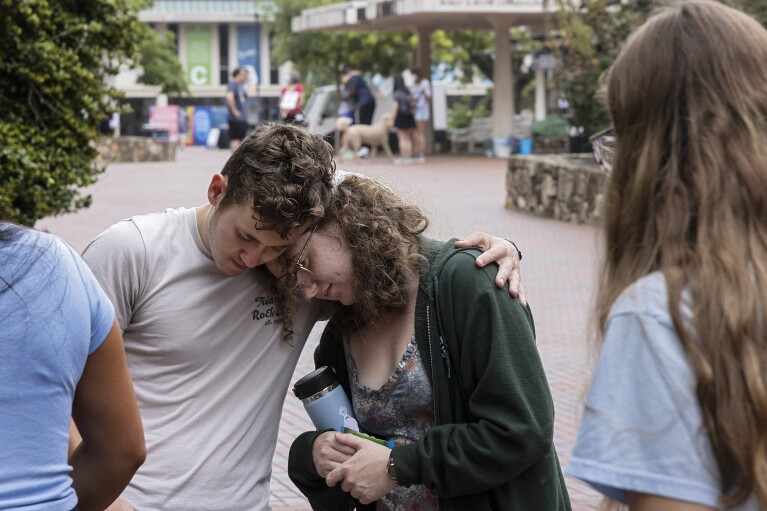 University of North Carolina Chapel Hill first-year students Lucas Moore and Katie Fiore embrace on Tuesday, Aug. 29, 2023, in Chapel Hill, N.C. following a Monday shooting that left a faculty member dead on the university's campus./The News & Observer via AP)