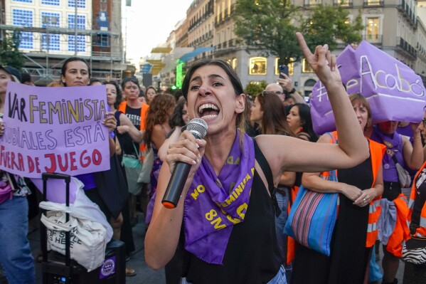 A demonstrator shouts slogans during a protest against the President of Spain's soccer federation Luis Rubiales and to support to support Spain's national women's soccer player Jenni Hermoso in Madrid on Monday, Aug. 28, 2023. Spain faces reckoning over sexism in soccer after federation head kisses player at Women's World Cup. Banner reads in Spanish "it's over" and "Rubiales is out of the game". (AP Photo/Andrea Comas)