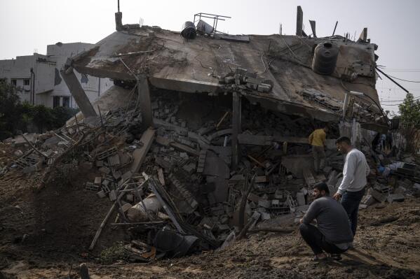 Palestinians inspect the rubble of a house after it was struck by an Israeli airstrike in Deir al-Balah, central Gaza Strip, Friday, May 12, 2023. (AP Photo/Fatima Shbair)