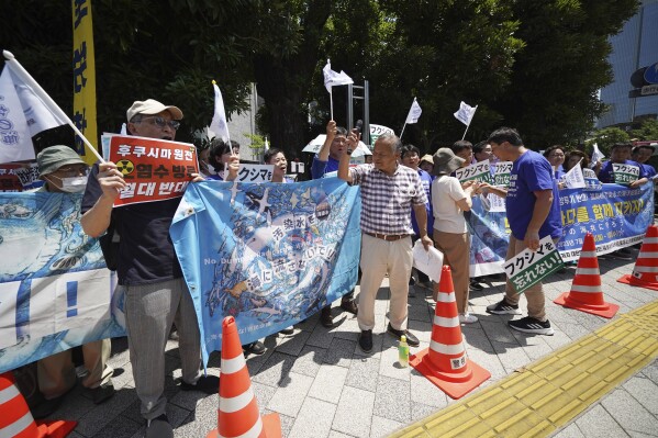Local protesters and South Korean lawmakers hold banners against Japanese plans to release treated wastewater from the damaged Fukushima nuclear power plant, during a rally in front of the Prime Minister's office Monday, July 10, 2023, in Tokyo. The banner, center, reads, "Do not release polluted water!!" (AP Photo/Eugene Hoshiko)