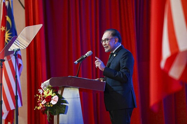 In this photo released by Malaysia's Department of Information, Malaysian Prime Minister Anwar Ibrahim speak during a business luncheon with China's Premier Li Qiang at a hotel in Kuala Lumpur, Malaysia, Thursday, June 20, 2024. (Malaysia's Department of Information via AP)