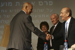FILE - Iraqi-born Israeli author Sami Michael, left, is congratulated by Israeli Prime Minister Ehud Olmert, right, as he receives an Emet Prize in Jerusalem Wednesday, Nov. 7, 2007. Sami Michael, an award-winning Iraqi-Israeli author who was known for writing poignantly about oppressed minorities and the challenges faced by Jews from Arab countries, has died. He was 97. (AP Photo / Jim Hollander, Pool, File)