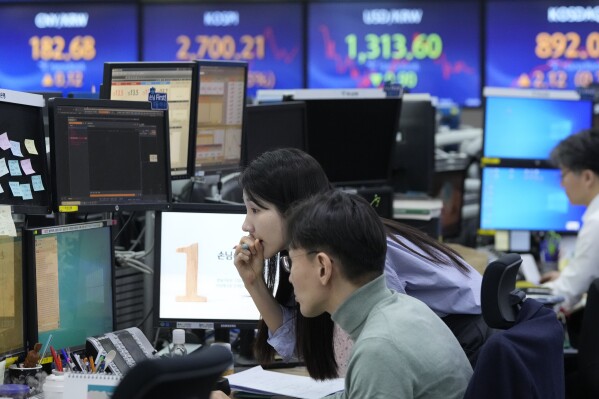 Currency traders watch monitors at the foreign exchange dealing room of the KEB Hana Bank headquarters in Seoul, South Korea, Thursday, March 14, 2024. Asian shares mostly declined Thursday in lackluster trading after U.S. stocks drifted to a mixed finish.(AP Photo/Ahn Young-joon)