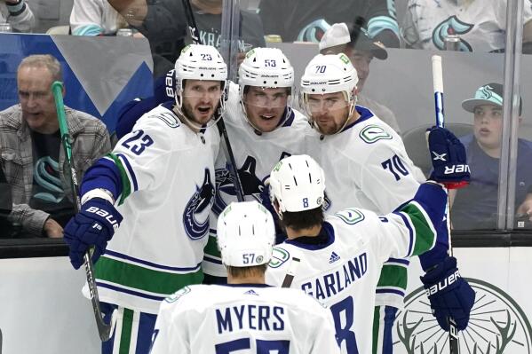 Vancouver Canucks' Bo Horvat (53) is congratulated by teammates after scoring against the Seattle Kraken durihng the second period of an NHL hockey game Saturday, Oct. 23, 2021, in Seattle. (AP Photo/Elaine Thompson)