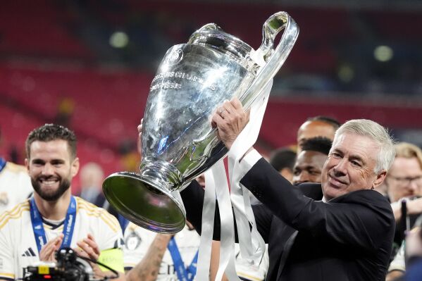 Real Madrid manager Carlo Ancelotti celebrates with the trophy after winning the Champions League final soccer match between Borussia Dortmund and Real Madrid at Wembley stadium in London, Saturday, June 1, 2024. Nick Potts/PA via AP)
