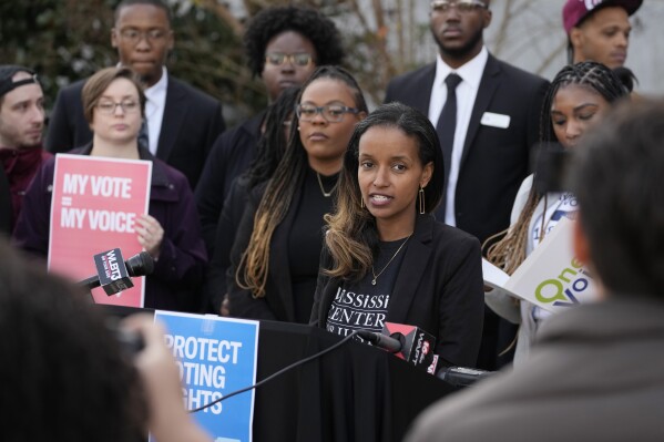 Harya Tarekegn with the Mississippi Center for Justice, center, joins members of other voting rights groups at a news conference in Jackson, Miss., on Thursday, Dec. 7, 2023. (APPhoto/Rogelio V. Solis)