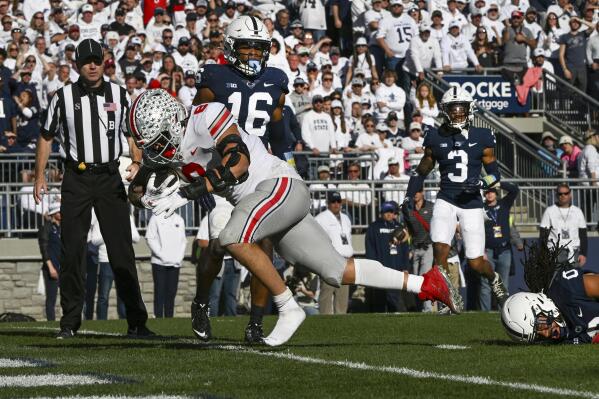 Ohio State tight end Cade Stover (8) scores a touchdown as Penn State defenders Jonathan Sutherland (0) and Ji'Ayir Brown (16) look on in the fourth quarter of an NCAA college football game, Saturday, Oct. 29, 2022, in State College, Pa. Ohio State won 44-31. (AP Photo/Barry Reeger)