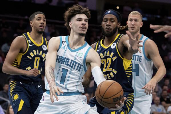 Charlotte Hornets guard LaMelo Ball (1) passes the ball while guarded by Indiana Pacers forward Isaiah Jackson (22) during the first half of an NBA preseason basketball game in Charlotte, N.C., Wednesday, Oct. 5, 2022. (AP Photo/Jacob Kupferman)