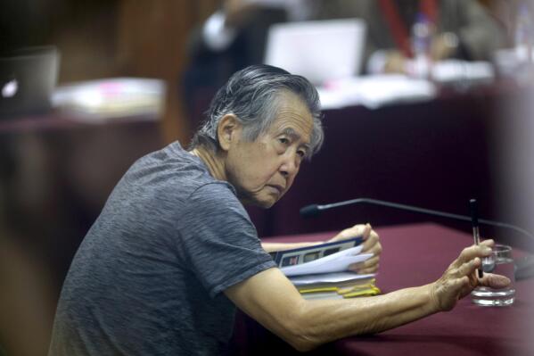 FILE - Jailed former Peruvian President Alberto Fujimori, photographed through a glass window, attends his trial at a police base on the outskirts of Lima, Peru, April 23, 2014. Peru's Constitutional Court on Thursday, March 17, 2022, approved the release from prison of Fujimori, who is serving a 25-year sentence for murder and corruption charges. (AP Photo/Martin Mejia, File)
